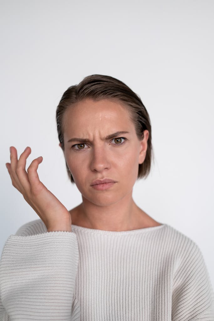 A confused young woman with a questioning facial expression on a white background.